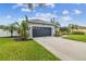 House exterior, featuring a black garage door and palm trees at 1604 21St W Ave, Palmetto, FL 34221