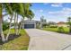 Home exterior with a large driveway and tropical landscaping at 1604 21St W Ave, Palmetto, FL 34221