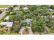 Aerial view of a house nestled in lush greenery, featuring a unique driveway at 1702 Spoonbill Dr, Nokomis, FL 34275