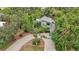 House with a circular driveway, surrounded by lush trees at 1702 Spoonbill Dr, Nokomis, FL 34275