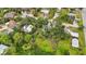 An aerial shot showcasing a house surrounded by dense trees and other homes at 1702 Spoonbill Dr, Nokomis, FL 34275