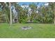 Large backyard with fire pit and tropical landscaping at 1702 Spoonbill Dr, Nokomis, FL 34275