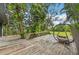 Wooden deck overlooking backyard with hanging chair at 1702 Spoonbill Dr, Nokomis, FL 34275