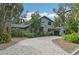 Two-story house with gray siding, paver driveway, and lush landscaping at 1702 Spoonbill Dr, Nokomis, FL 34275