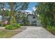 Two-story house with gray siding, paver driveway, and lush landscaping at 1702 Spoonbill Dr, Nokomis, FL 34275