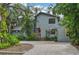 Two-story house with gray siding, paver driveway, and tropical landscaping at 1702 Spoonbill Dr, Nokomis, FL 34275