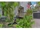 Landscaped front yard with pond and tropical plants at 1702 Spoonbill Dr, Nokomis, FL 34275