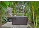 Brown hot tub on a patio surrounded by tropical foliage at 1702 Spoonbill Dr, Nokomis, FL 34275