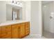 Bright bathroom features a wood vanity, large mirror, and a walk-in shower at 1817 New London St, North Port, FL 34288