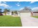 Charming single-story home with a well-manicured lawn, two-car garage, and inviting front entrance at 1817 New London St, North Port, FL 34288