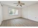 Sunny bedroom features plank flooring, a ceiling fan, and a window with vertical blinds at 1853 Restful Dr # L2, Bradenton, FL 34207