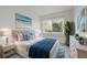 Comfortable bedroom with natural light, beachy artwork, and blue and white bedding at 1853 Restful Dr # L2, Bradenton, FL 34207