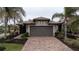 Single-story home with a gray garage door and tile roof, nestled in a landscaped yard at 19261 Isadora St, Venice, FL 34293