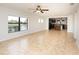 Open living area with tile flooring, kitchen views, and ceiling fan at 19261 Isadora St, Venice, FL 34293