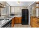 Galley kitchen with wood cabinets, black appliances, and tile floor at 2047 Canal Dr # L6, Bradenton, FL 34207