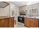 Kitchen with wood cabinets, white appliances, and tile floor at 2047 Canal Dr # L6, Bradenton, FL 34207