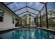 Screened-in pool with lounge chairs and covered patio at 22490 Madelyn Ave, Port Charlotte, FL 33954