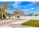 Tan house with white garage door and landscaping at 2341 Spring Oaks Cir, Sarasota, FL 34234