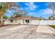 Tan house with white garage door and landscaping at 2341 Spring Oaks Cir, Sarasota, FL 34234