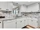 White kitchen with marble countertops and stainless steel appliances at 2341 Spring Oaks Cir, Sarasota, FL 34234