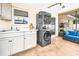 Outdoor laundry room with stackable washer and dryer, plus a sink and cabinets at 2341 Spring Oaks Cir, Sarasota, FL 34234