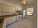 Condo kitchen with white cabinets, appliances, and tile floor at 2599 Woodgate Ln # K7, Sarasota, FL 34231