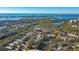 An aerial view showcasing a waterfront community and a homesite with mature trees at 32 Bayhead Ln, Osprey, FL 34229