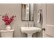 Elegant powder room with pedestal sink, frameless mirror, and decorative accents at 32 Bayhead Ln, Osprey, FL 34229