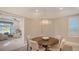 Bright dining room with round wooden table, four chairs, and a stylish light fixture at 32 Bayhead Ln, Osprey, FL 34229