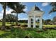 White gazebo nestled in lush landscaping near a golf course at 32 Bayhead Ln, Osprey, FL 34229