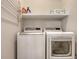 Convenient laundry room with washer, dryer, and storage shelf at 32 Bayhead Ln, Osprey, FL 34229