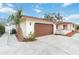 Attached garage with brown door and side yard landscaping at 320 Whitfield Ave, Sarasota, FL 34243