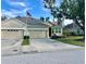 Tan house with gray roof, three-car garage, and manicured lawn at 3312 92Nd E Ave, Parrish, FL 34219