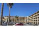 Condo building showing tan exterior, multiple balconies, parking lot and palm trees in the background on a sunny day at 3682 Lake Bayshore Dr # K402, Bradenton, FL 34205