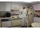 Galley kitchen with white cabinets and appliances at 3682 Lake Bayshore Dr # K402, Bradenton, FL 34205