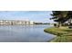 Scenic view of the lake with well-maintained grass and condo buildings visible in the distance at 3682 Lake Bayshore Dr # K402, Bradenton, FL 34205