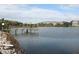 Scenic view of the lake with a shaded wooden dock and condo building in the distance at 3682 Lake Bayshore Dr # K402, Bradenton, FL 34205