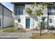 Updated condo exterior with a teal door and well-manicured landscaping at 4001 Beneva Rd # 208, Sarasota, FL 34233