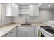 White kitchen cabinets, granite countertops, and stainless steel appliances at 4001 Beneva Rd # 208, Sarasota, FL 34233