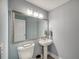 Small bathroom with pedestal sink, toilet, and framed mirror at 4201 Palacio Dr, Sarasota, FL 34238