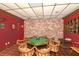 Game room with an octagonal game table and brick walls at 4310 Falmouth Dr # A104, Longboat Key, FL 34228