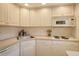 White kitchen cabinets, microwave, and stove at 4310 Falmouth Dr # A104, Longboat Key, FL 34228