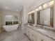 Luxurious bathroom with double vanity, granite countertops, and a soaking tub at 4539 Longspur Ln, Sarasota, FL 34238