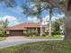 Tan house with red tile roof, palm trees, and a spacious front yard at 4539 Longspur Ln, Sarasota, FL 34238