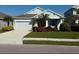 Single-story home with light blue exterior, landscaping, and a two-car garage at 4629 Garden Arbor Way, Bradenton, FL 34203