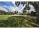 Exterior view of clubhouse with patio seating, lush landscaping, and palm trees at 4838 88Th E St, Bradenton, FL 34211