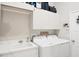 Bright laundry room with white cabinets, washer, dryer, and utility sink at 4838 88Th E St, Bradenton, FL 34211