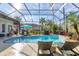 Inviting pool area with screened enclosure, lounge chairs, and lush landscaping at 4838 88Th E St, Bradenton, FL 34211