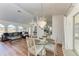 Bright dining room with glass top table and chandelier, open to living room at 5 Pinehurst Ct, Rotonda West, FL 33947