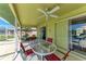 Relaxing patio with table, chairs, and ceiling fan at 5 Pinehurst Ct, Rotonda West, FL 33947